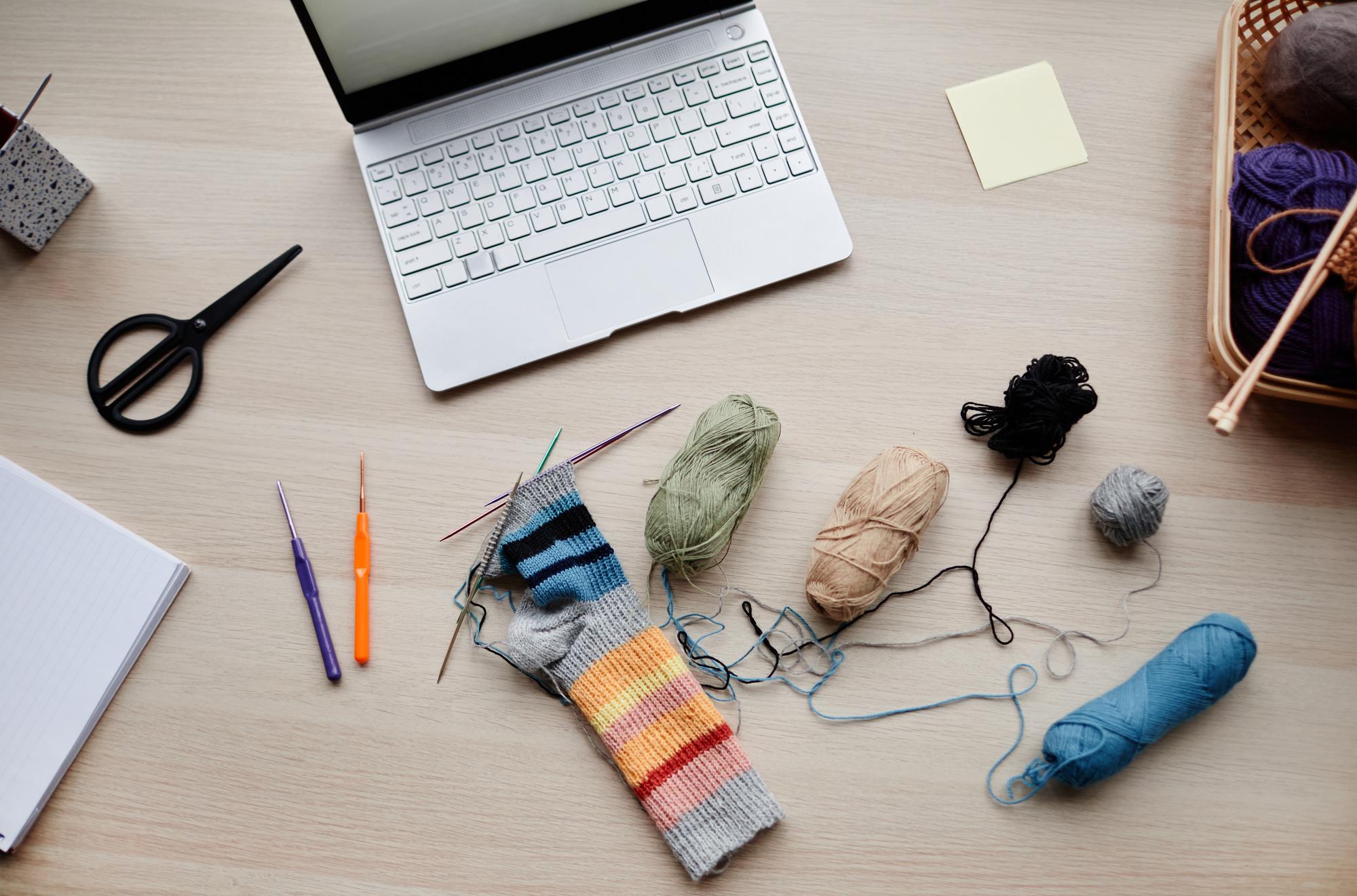 Workspace with threads, needles and embroidered sampler
